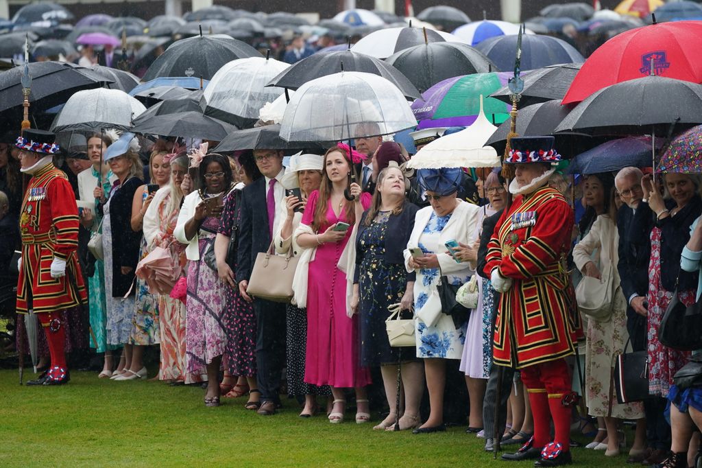 Rainy view of guests with umbrellas at Buckingham Palace Garden Party