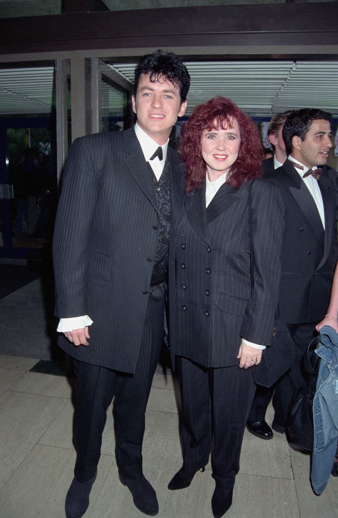 Shane Richie standing with Coleen Nolan in matching pinstripe suits