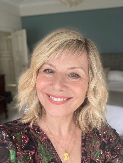 woman smiling wearing a dark printed shirt