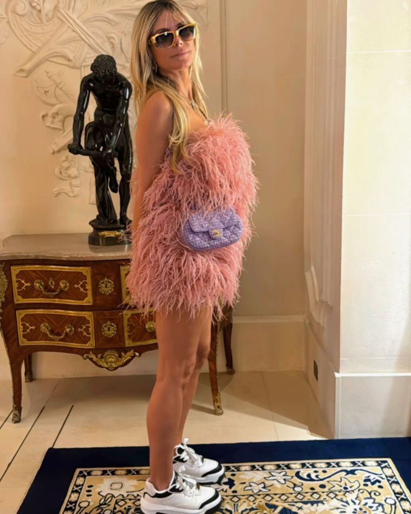 Heidi Klum poses in a feathered mini dress ahead of spending the day in Paris