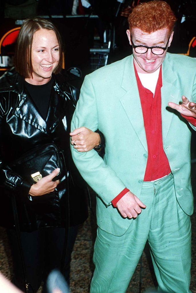Carol McGiffin in a leather jacket with Chris Evans in a red shirt and green suit