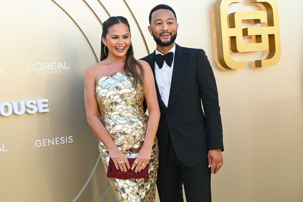 Chrissy Teigen et John Legend devant un fond d'or