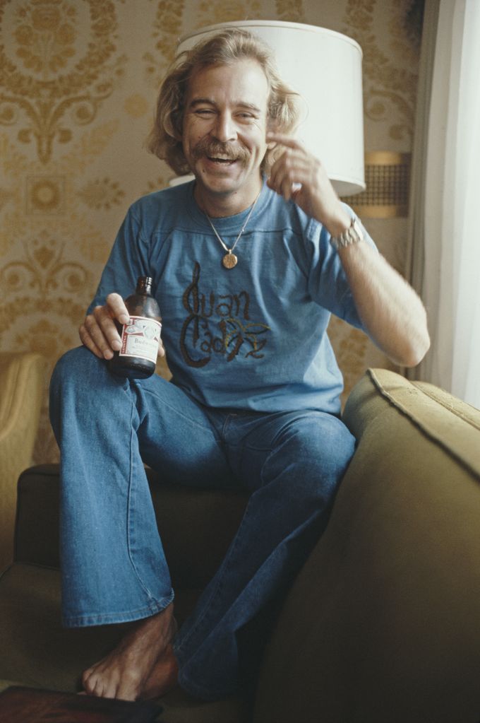 Jimmy Buffett pictured holding a bottle of Budweiser beer during an interview in New York, 3rd August 1977