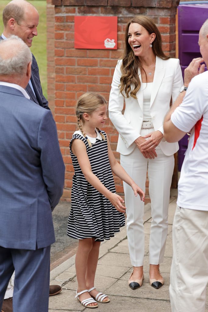 Princess Kate wears a white suit while Princess Charlotte wears a nautical striped dress