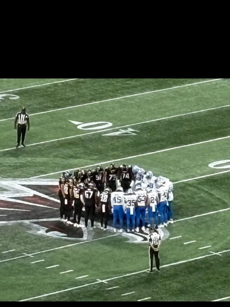 Falcons and Lions come together in a prayer circle for Morice Norris