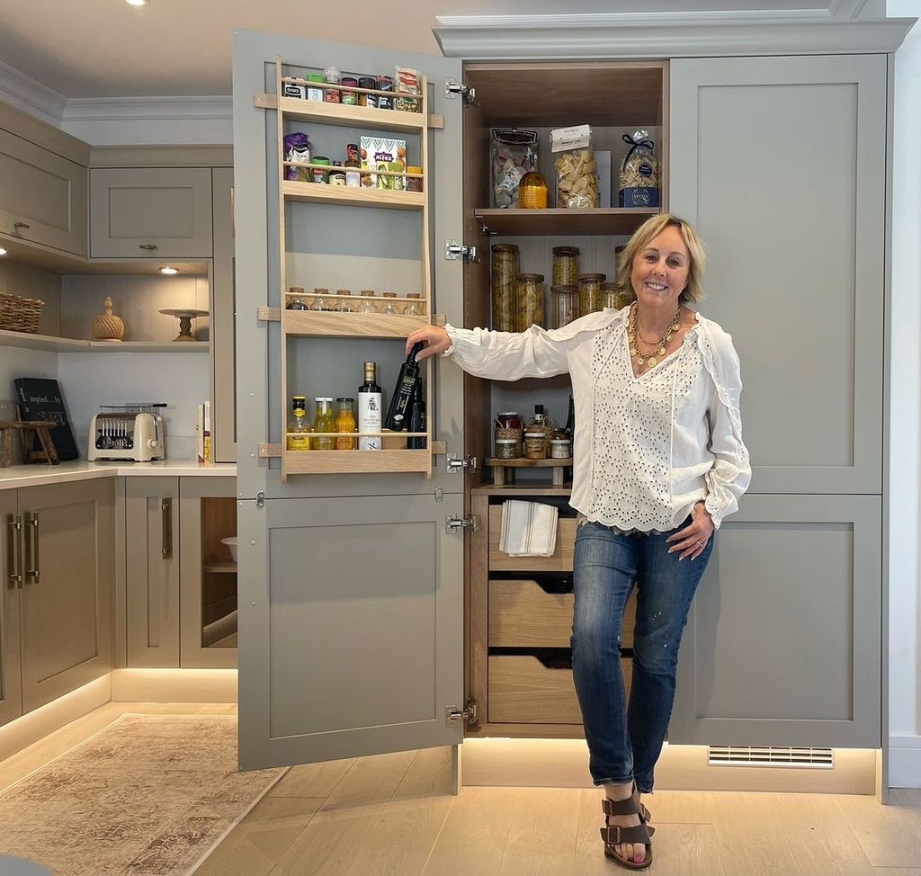 Shirlie Kemp smiles as she stands in front of kitchen pantry