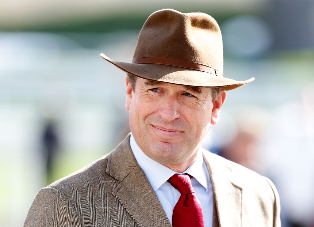 man wearing jacket and hat at races 