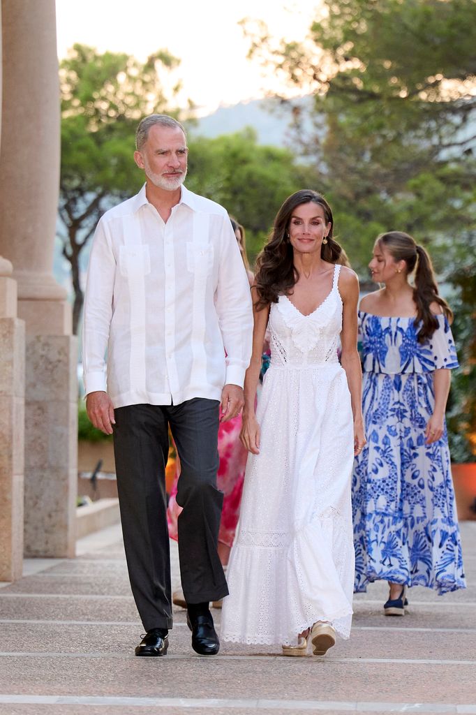 King Felipe in white shirt and trousers and Queen Letizia in white dress