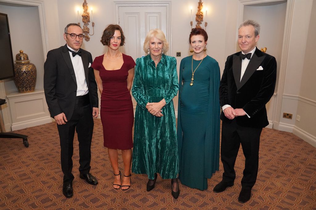 camilla in green dress with guests