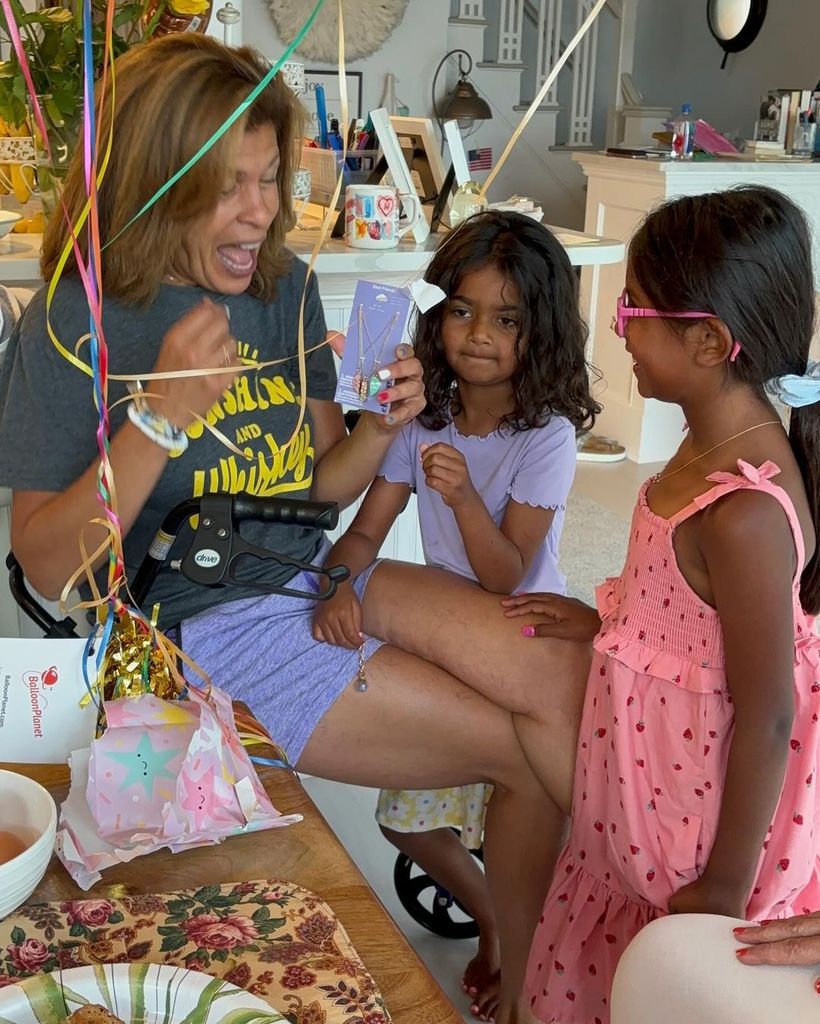 Hoda Kotb sits with daughters Hope and Haley as she opens birthday gifts