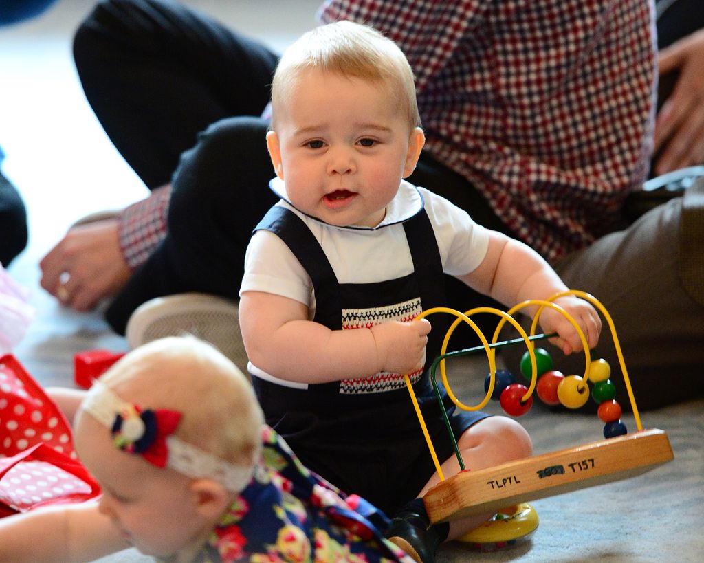 A baby Prince George playing with toys