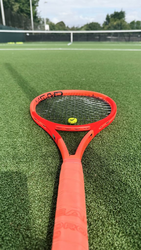 Red tennis racket on court 