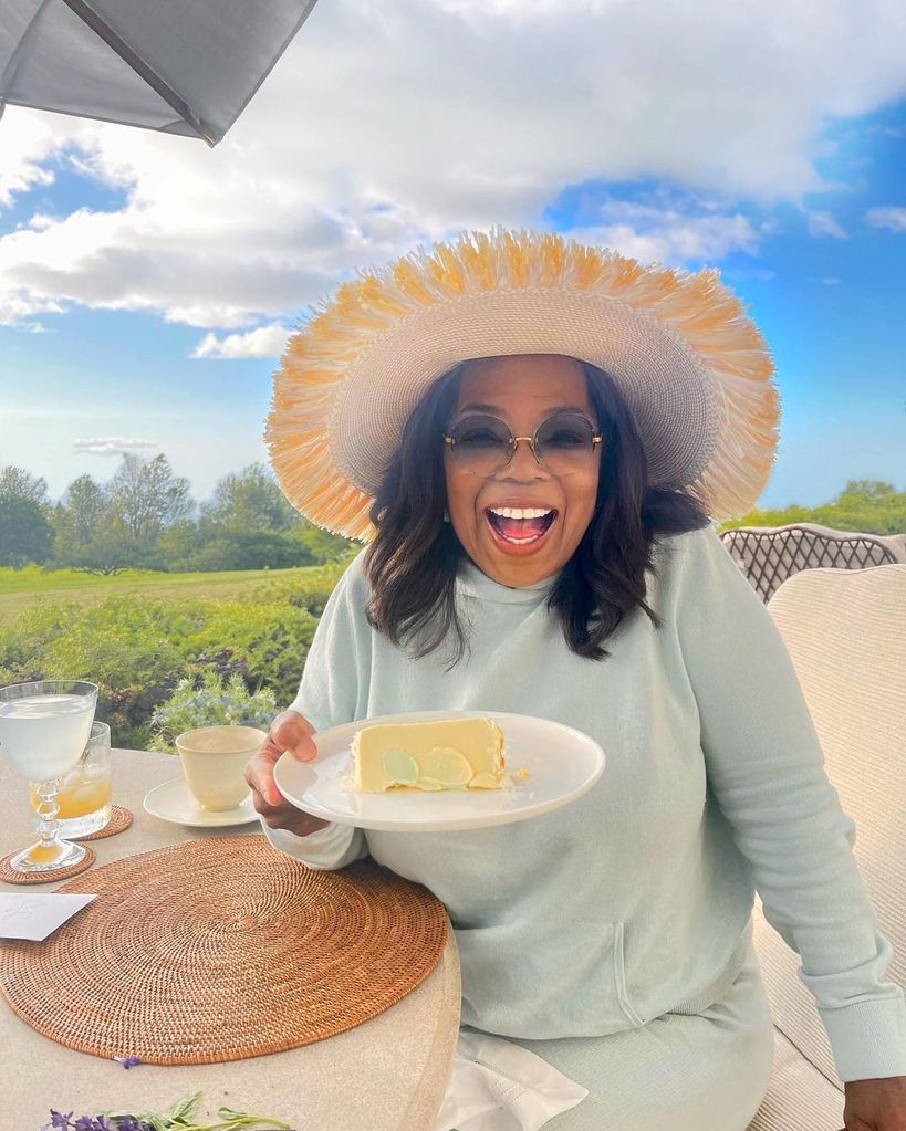 oprah winfrey smiling holding slice of cake