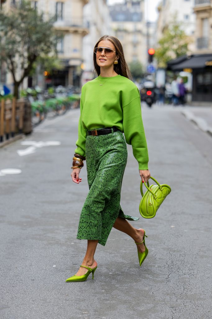 Nina Sandbech wears green top with long sleeves and bracelets Zara, skirt with snake print Gestuz, bag Mietis, shoes Prada, sunglasses Loewe during Womenswear Spring/Summer 2025 as part of  Paris Fashion Week on September 29, 2024 in Paris, France.