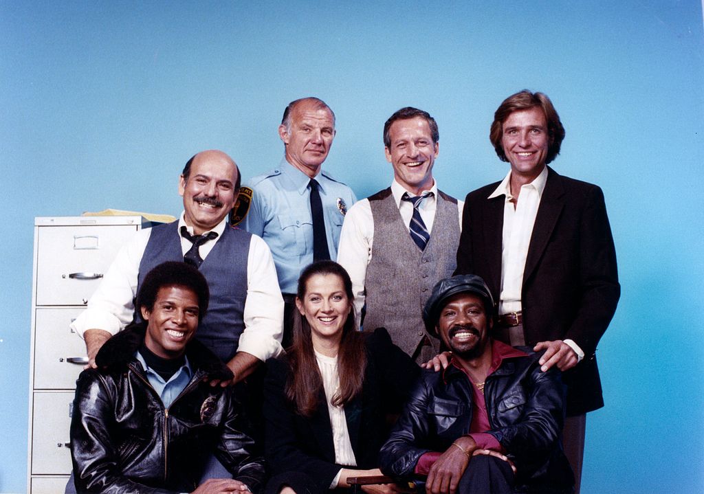 HILL STREET BLUES -- Season 1 -- Pictured: (Seated, l-r) Michael Warren as Officer Robert 'Bobby' Hill, Daniel J. Travanti as Capt. Frank Furillo, Taurean Blacque as Det. Neal Washington, (Back, l-r) Rene Enriquez as Capt. Ray Calletano, Michael Conrad as Sgt. Phil Esterhaus, Daniel J. Travanti as Capt. Frank Furillo, Kiel Martin as Officer John 'J.D.' LaRue -- (Photo by: Herb Ball/NBCU Photo Bank/NBCUniversal via Getty Images via Getty Images)