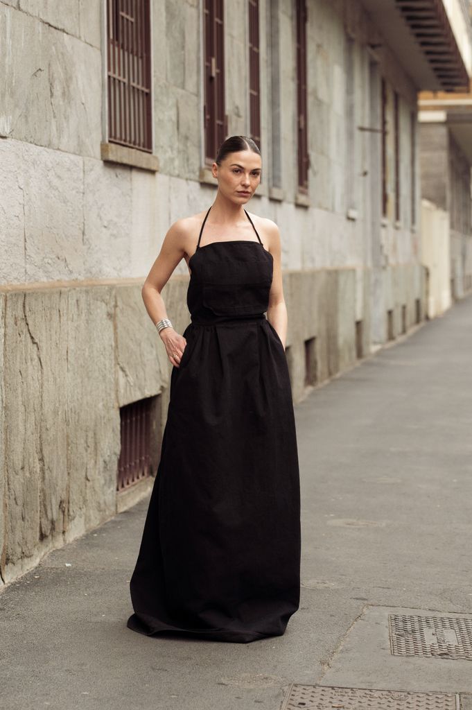 Sophia Roe wears black heeled sandals, and a black shoulder-less dress outside Max Mara 