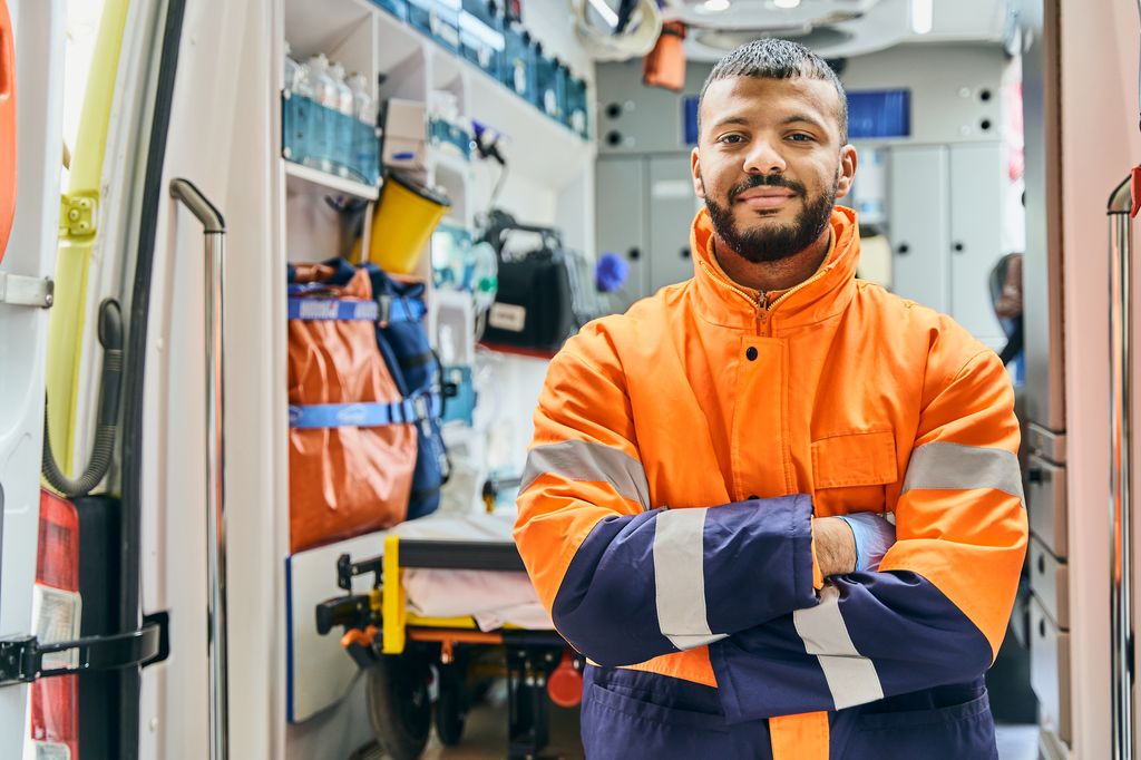 Portrait man paramedic in front of ambulance.