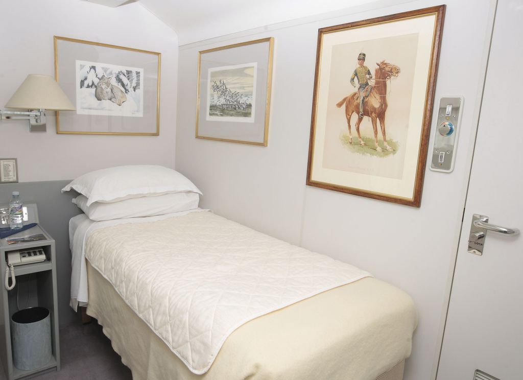 A single bed with horse pictures on the wall