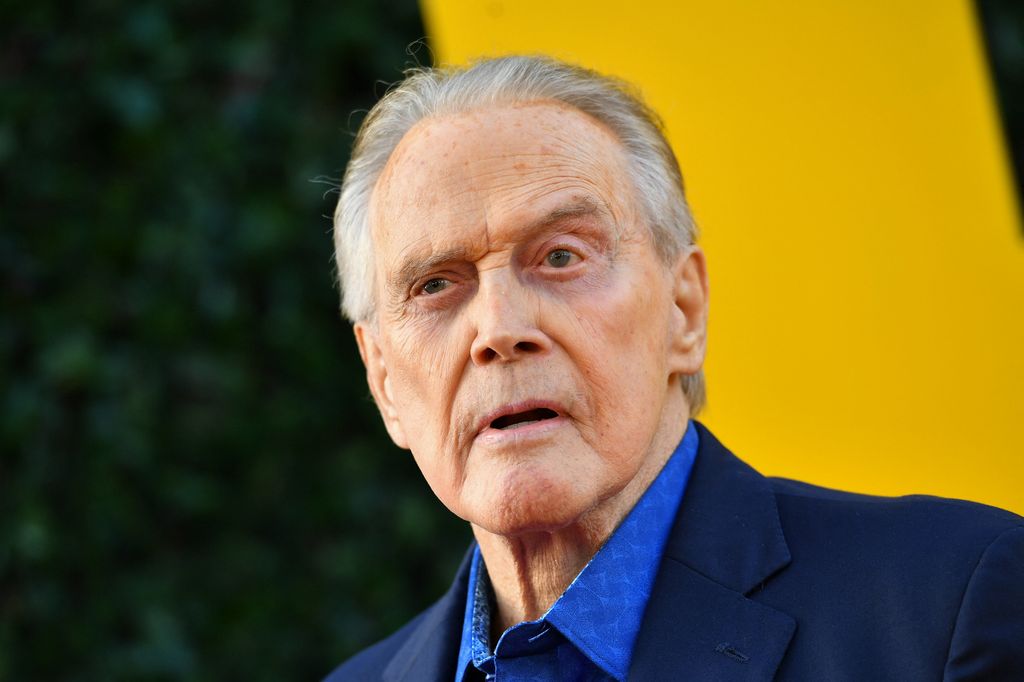 Lee Majors posing at a premiere wearing a blue suit
