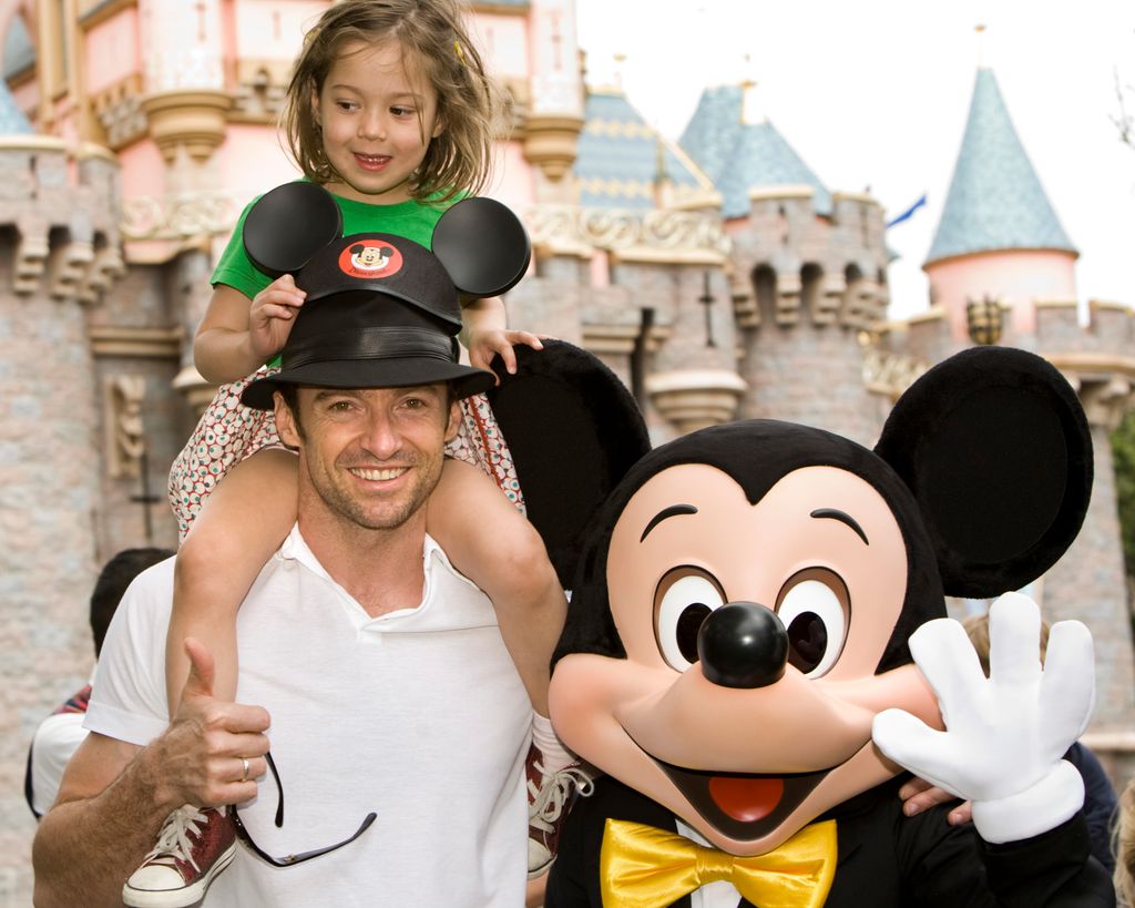 photo of hugh jackman with daughter ava on his shoulders next to mickey mouse