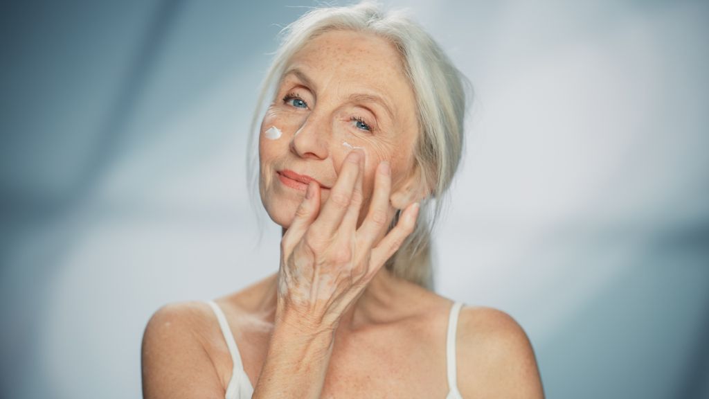 Older lady applying face cream 