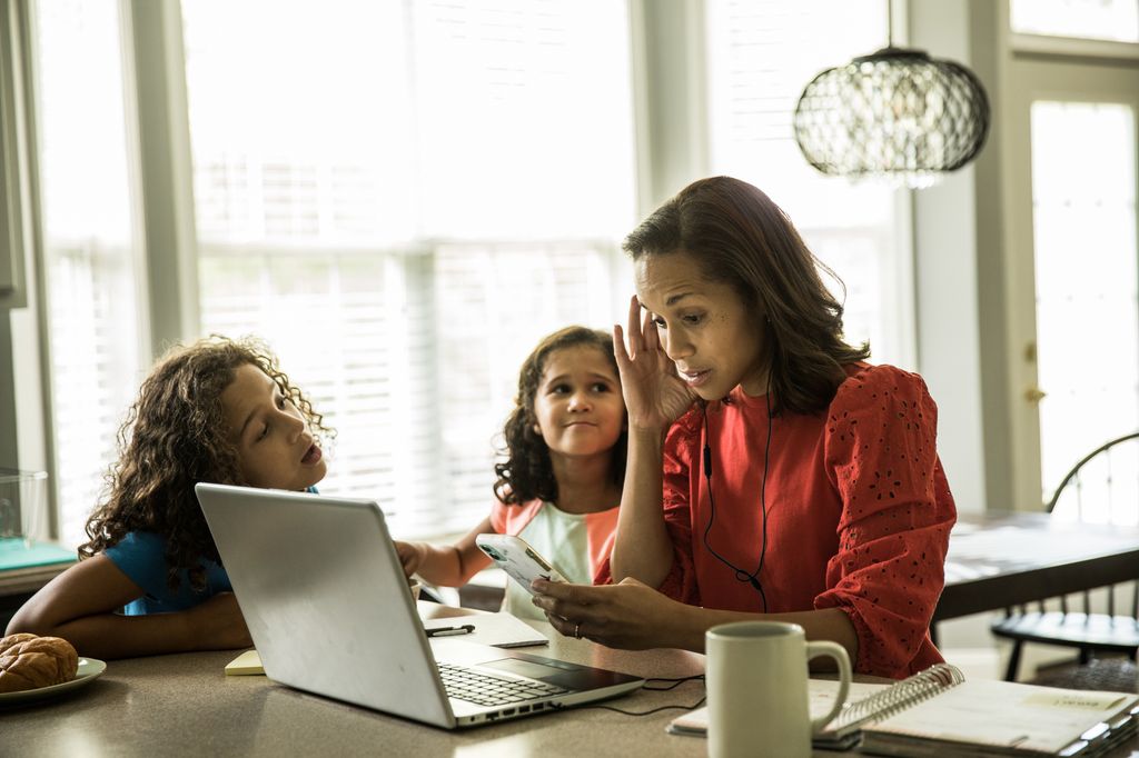 Mother working from home with children in background