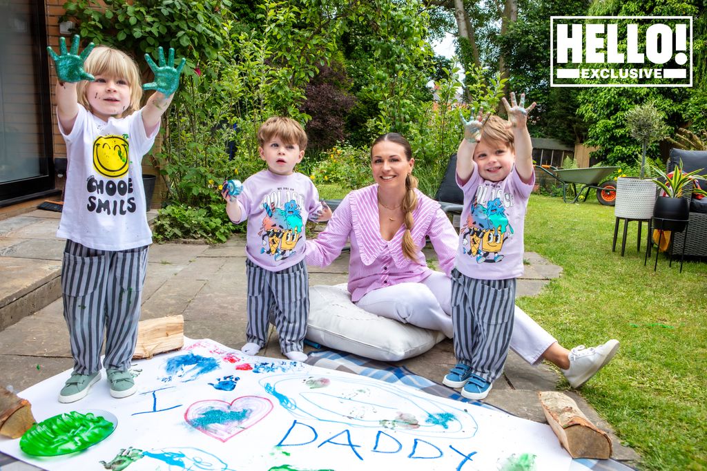 Jessica Holmes mit ihren drei kleinen Kindern und einem Schild mit der Aufschrift „ "Ich liebe Papa"