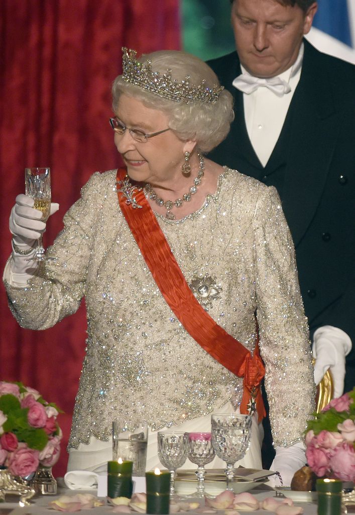 La reine Elizabeth II lève son verre pour porter un toast lors d'un banquet d'État offert par le président français François Hollande à l'Elysée le 6 juin 2014 à Paris.
