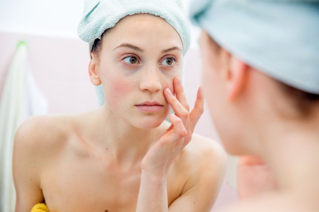 Young woman portrait in the mirror of her bathroom after taking shower
