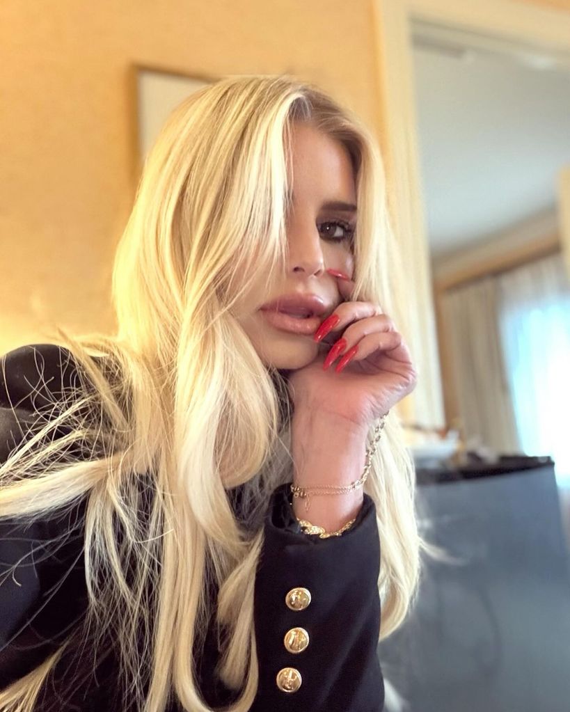 Jessica Simpson posing for selfie with blonde hair and pout