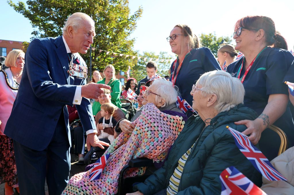 King Charles talking to two elderly ladies and their carers