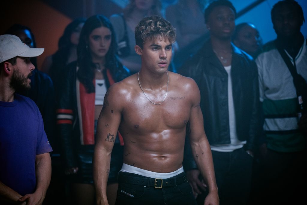 young man topless surrounded by people