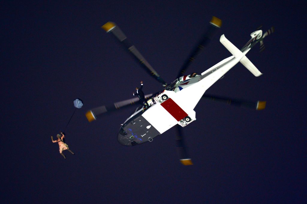 A performer in the role of Queen Elizabeth II parachutes out of a helicopter hovering above the stadium during the Opening Ceremony of the London 2012 Olympic Games