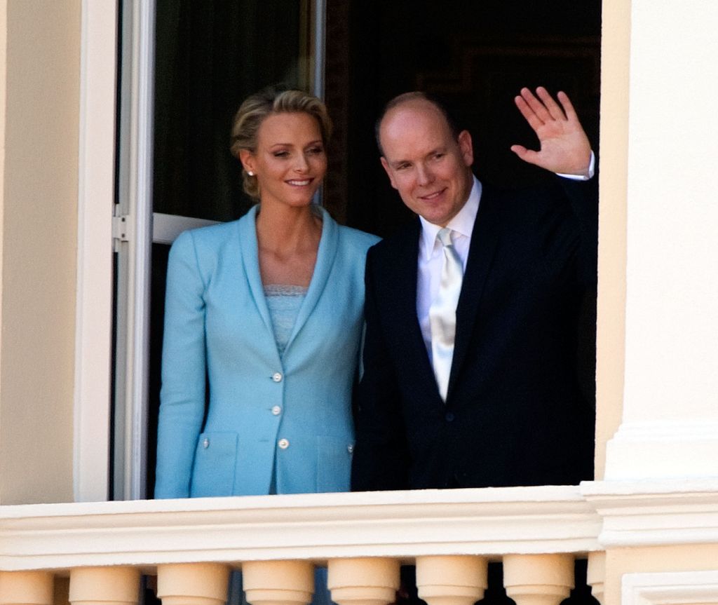 Princess Charlene and Prince Albert waving from balcony