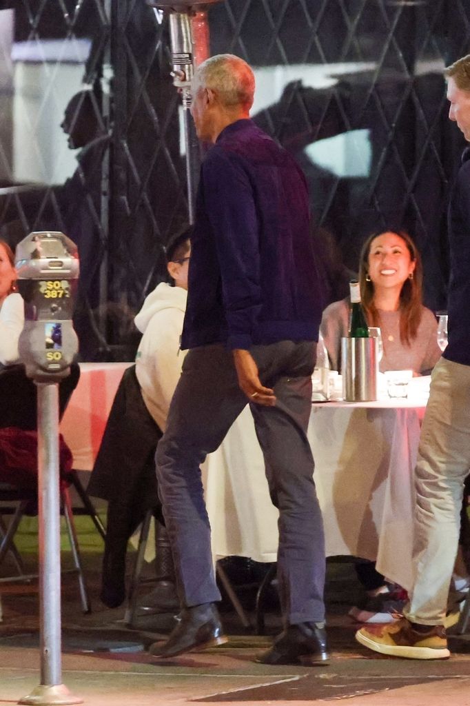 Barack walking into the restaurant from behind wearing wedding ring