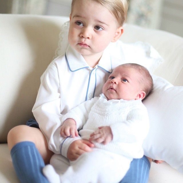 Prince George holding a baby Princess Charlotte