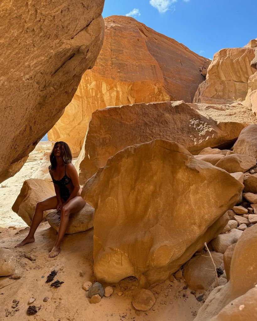 Halle Berry em lingerie de renda posando em uma pedra no deserto