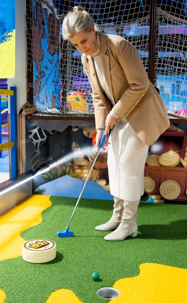 Sophie playing mini golf in oatmeal outfit