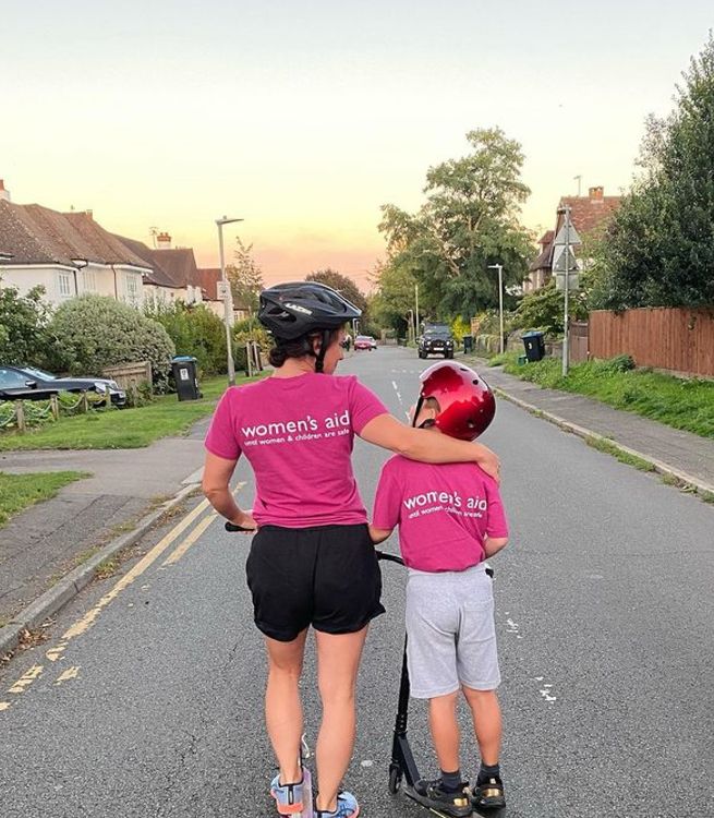 Lucy Gaskell and her son on scooters with t-shirts supporting Women's Aid