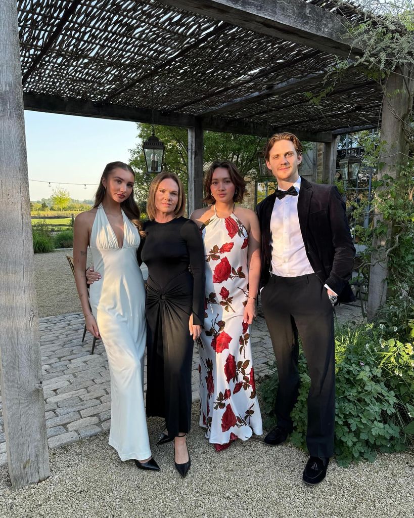 family of four posing outside in glam outfits 