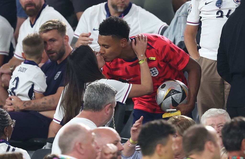 couple kissing in football stands 