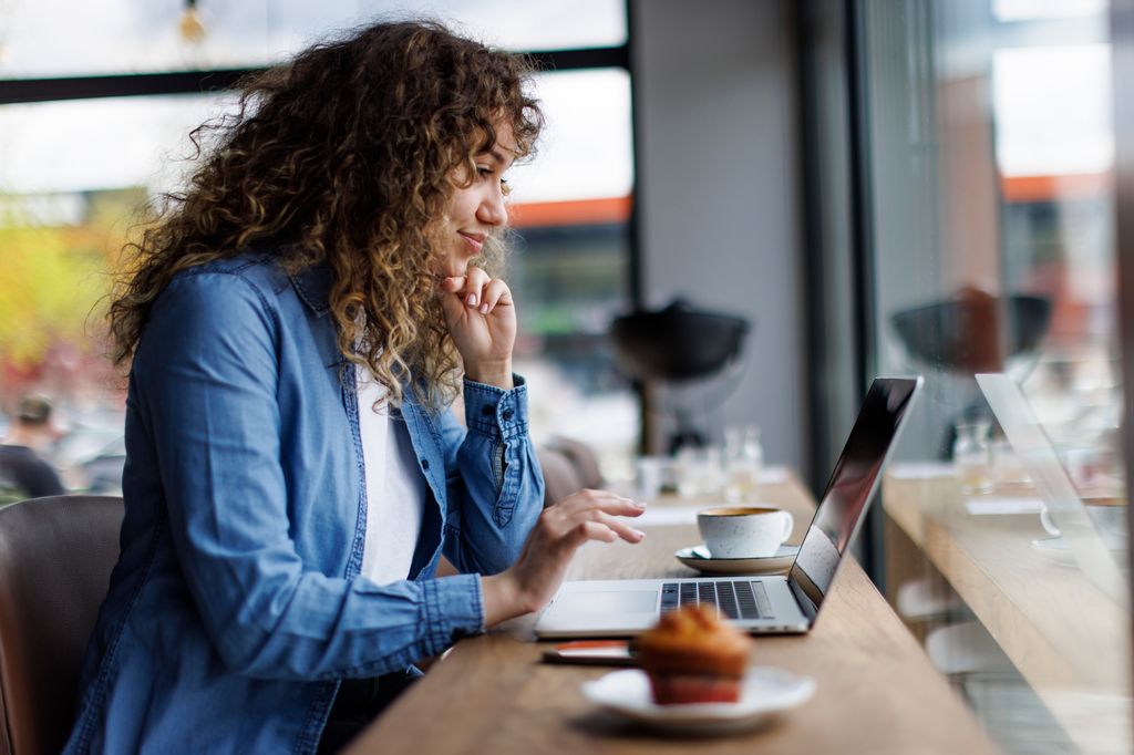 Young woman working on laptop at a cafe