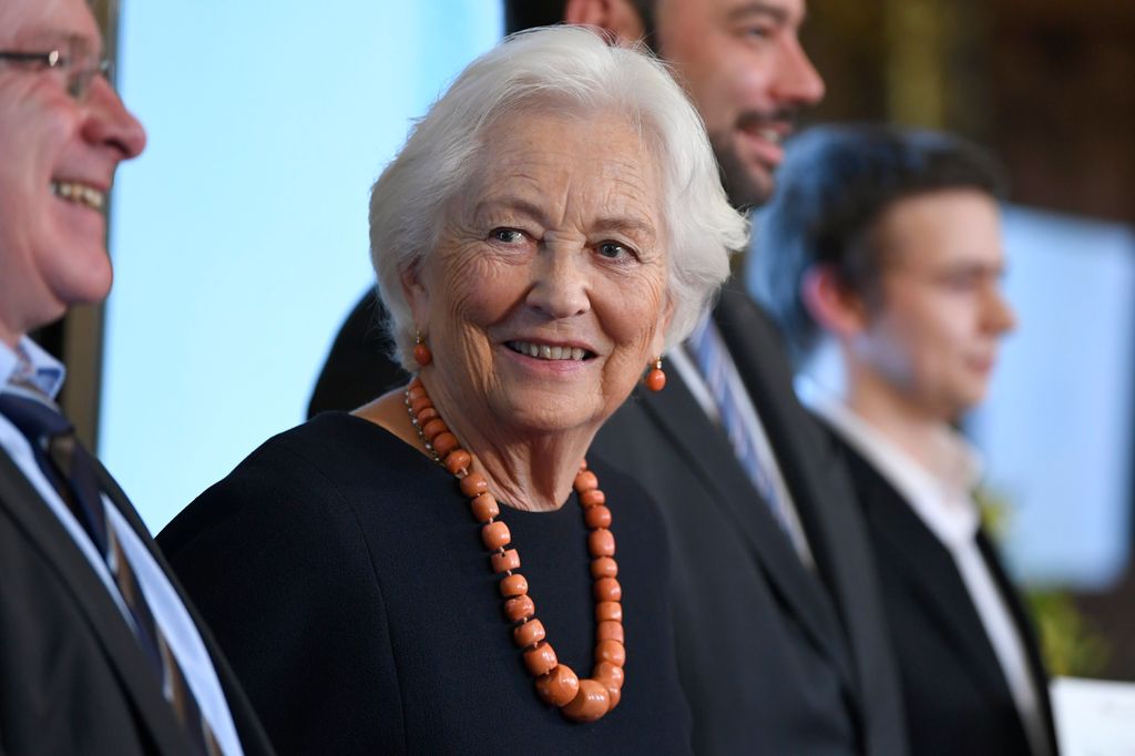Queen Paola in a black dress and large necklace