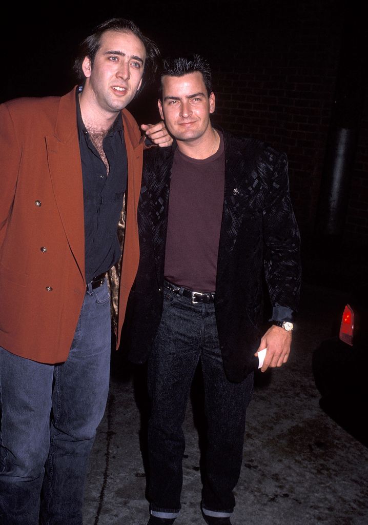 Nicolas Cage and actor Charlie Sheen attend the Party for Guess? Parfum's US Tour with Claudia Schiffer on October 13, 1990 at Arena in Hollywood, California