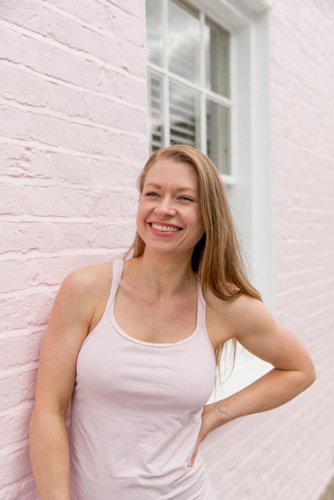 Woman in a pink top against a pink wall
