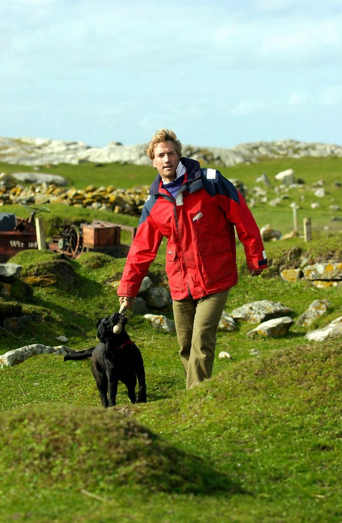 G50GTJ Castaway Benjamin Fogle takes his dog for a walk on the island of Taransay in the Western Isles of Scotland where he has been living since New Year's Eve as part of the BBC's Castaway 2000 television programme.