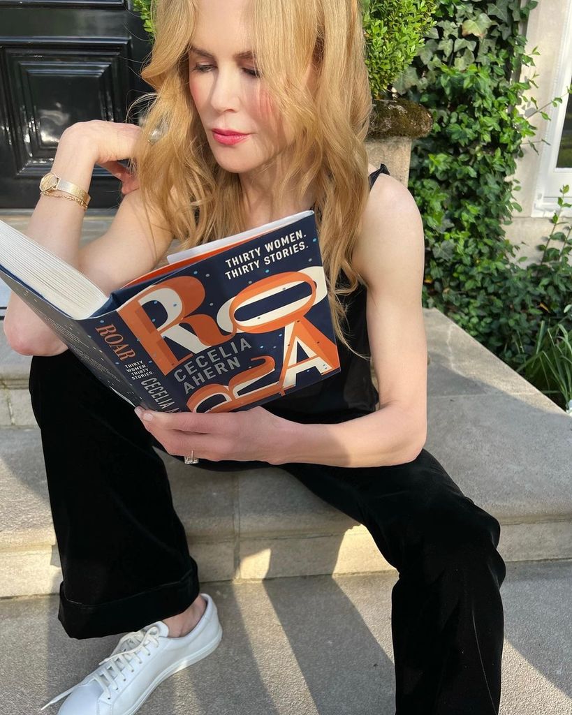 Nicole Kidman reading a book on her front steps