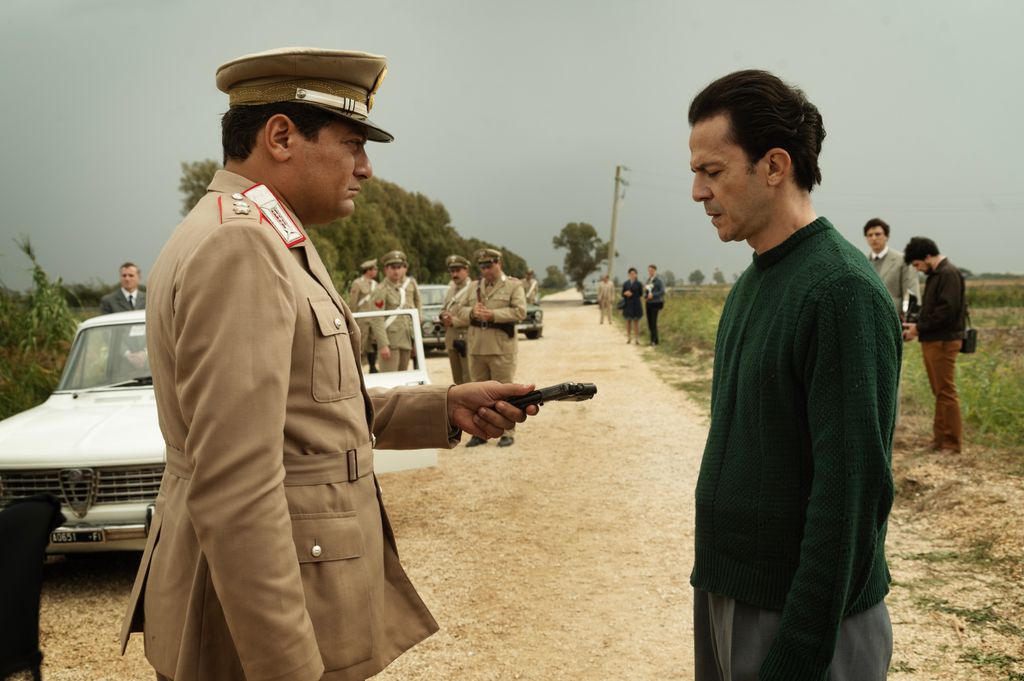 police officer holding gun opposite man