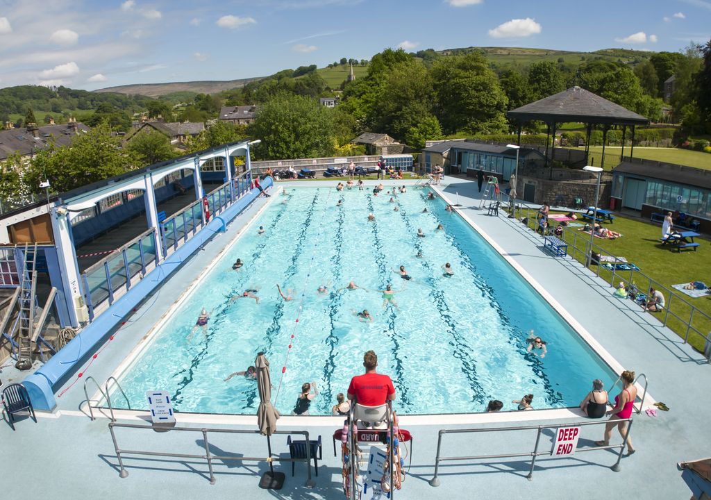 People enjoying the warm weather at Hathersage outdoor swimming pool in the Peak District .