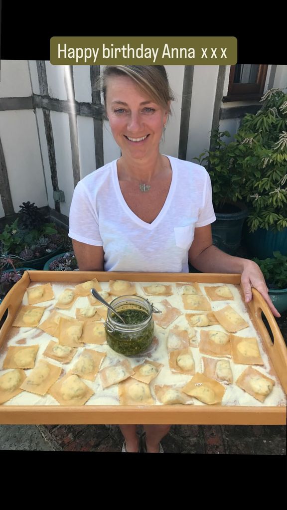 woman holding tray of homemade pasta